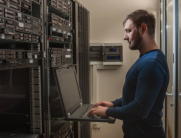 Profissional de TI operando servidores em um rack de data center